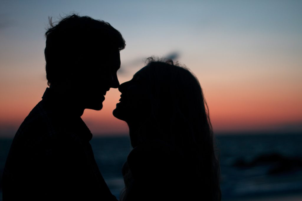 a silhouette of a couple at sunset