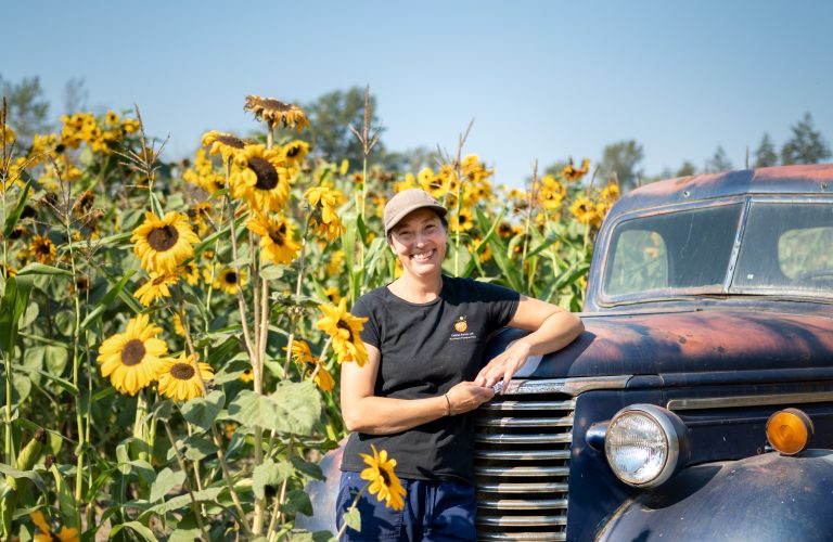 Shari form Hazelmere Pumpkin Patch leaning on an old car in front of sunflowers - Roland Kaufmann - South Surrey