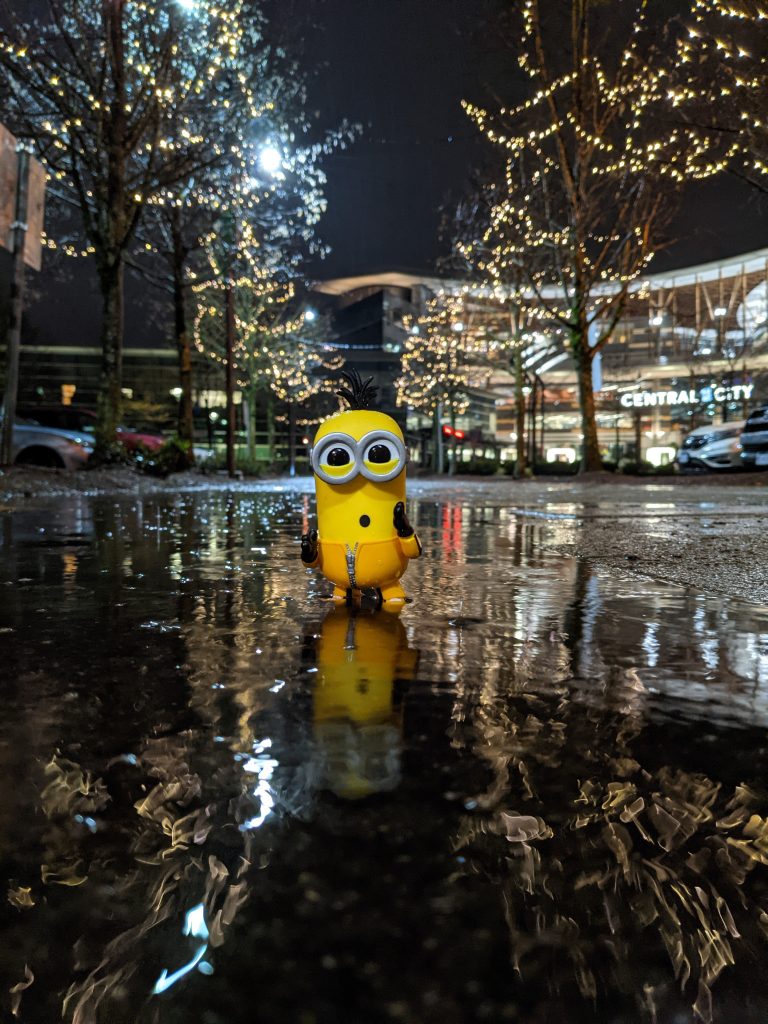 A minion figurine in front of festive lights on a rain-slicked surface - Sowjanya-Kiran - Surrey Through My Lens - North Surrey - Discover Surrey