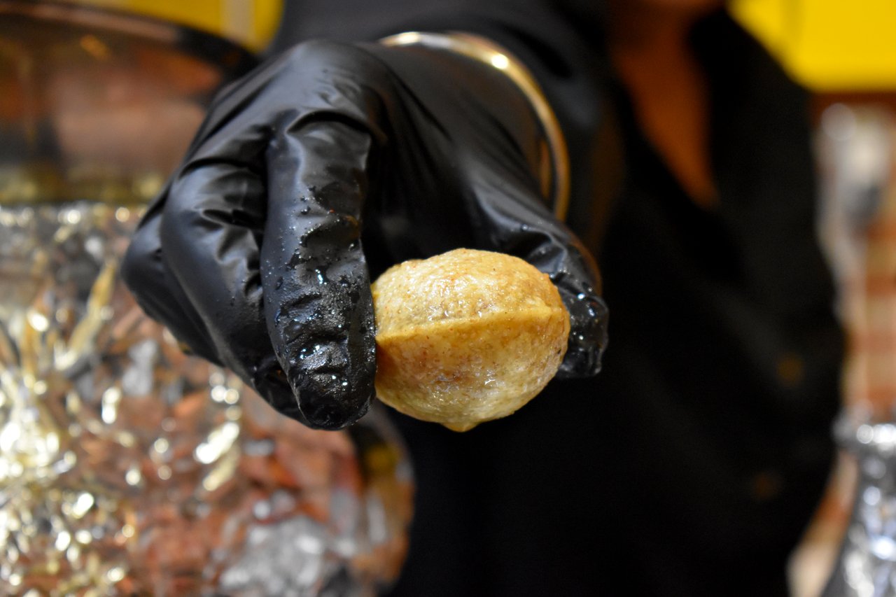 A close up image of a hand handing out a gol gappa from Apna Chaat in Newton. Surrey. Street Food Trail.