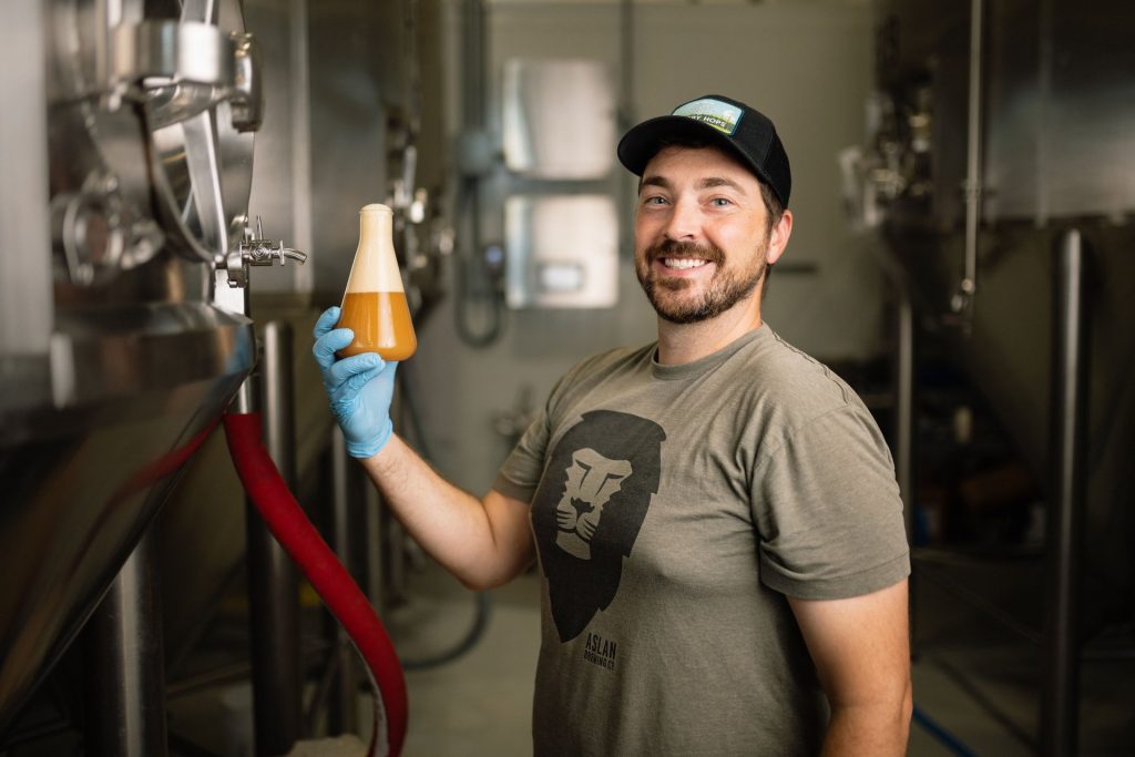 The brewmaster holding up a sample in a flask at Russell Brewing Company