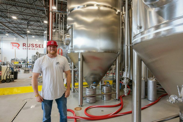 Russell Brewing Company Marketing Manager, Jimmy Darbyshire, in front of vats at the brewery